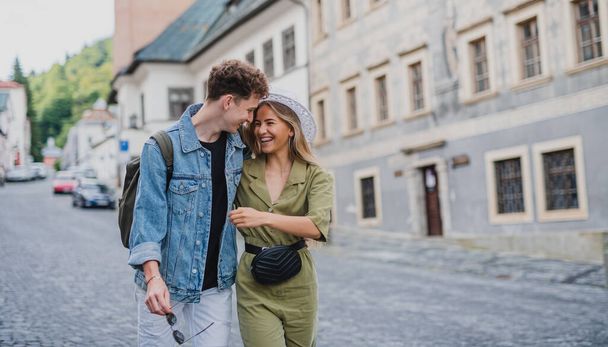Happy young couple outdoors on street on town trip, walking and talking. - Foto, Imagen