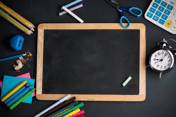 A blackboard on wood background with School supplies top view - Foto, afbeelding