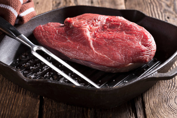 Raw meat and vegetables are prepared for grilling and barbecuing in a cast iron pan. Home grill - Фото, изображение