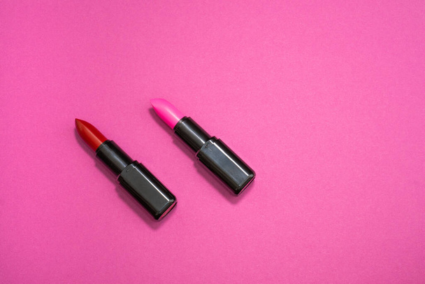 Fashion cosmetics photo of red and pink lipsticks on a pink background  - Фото, изображение