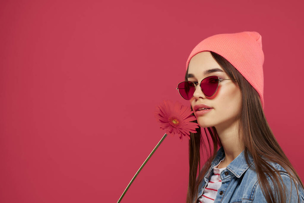dziewczyna noszenie okulary przeciwsłoneczne noszenie różowy kapelusz czerwony kwiat moda pozowanie romans - Zdjęcie, obraz