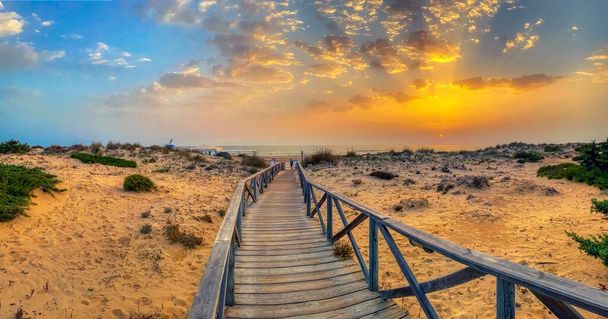 Песчаные дюны, которые дают доступ к пляжу Ла Барроса в Санкти Петри на закате, Кадис, Испания. - Фото, изображение