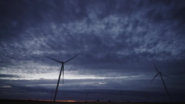 Закат солнца с облаками и современными ветряными турбинами, вращающимися быстро - Кадры, видео