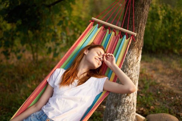 kaunis nainen makaa riippumatossa ulkona luonto puita - Valokuva, kuva