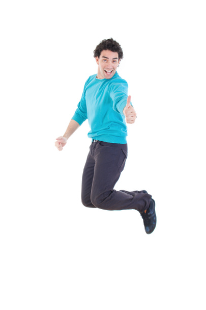 Iloinen nuori rento mies hyppii ilmassa osoittaa peukalo ylöspäin
 - Valokuva, kuva