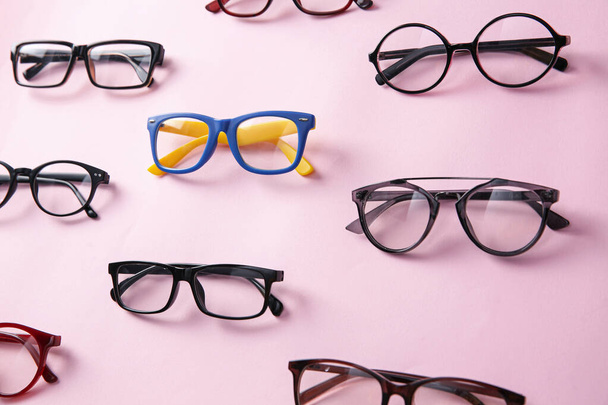 Colorful glasses among black ones on pink background. Diversity concept - Photo, image