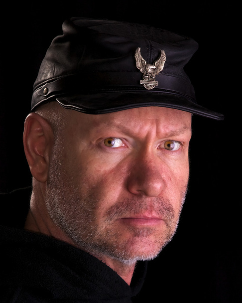 Motociclista vestindo um chapéu de guerra civil preto com emblema de águia
 - Foto, Imagem