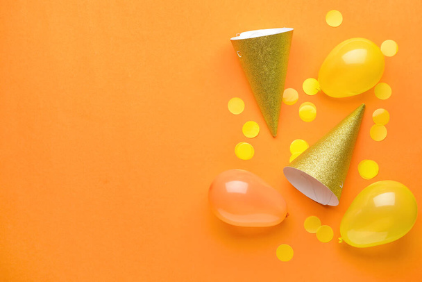 Sombreros de fiesta, globos y confeti sobre fondo de color - Foto, Imagen