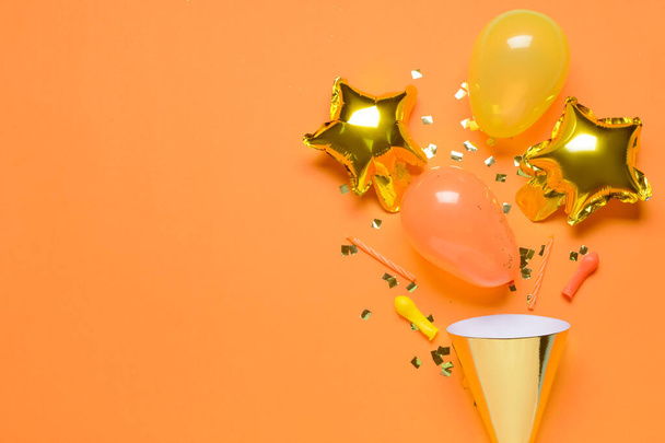 Feestmuts, ballonnen, kaarsen en confetti op kleur achtergrond - Foto, afbeelding