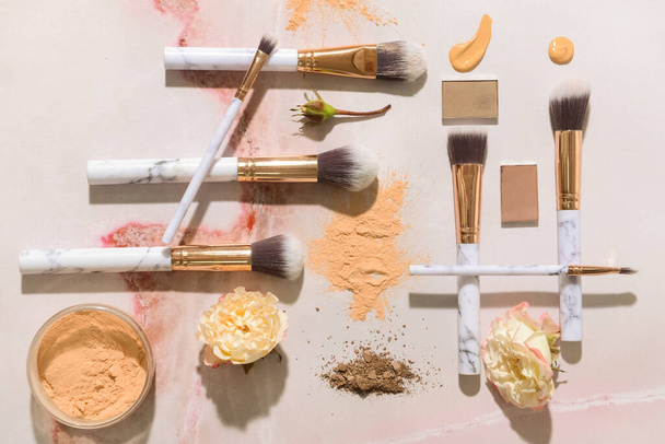 Set Make-up-Pinsel mit kosmetischen Proben auf hellem Hintergrund - Foto, Bild