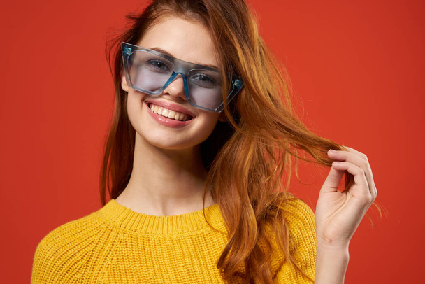 χαρούμενη ελκυστική γυναίκα κρατώντας τα μαλλιά γυαλιά στούντιο μόδας - Φωτογραφία, εικόνα