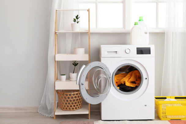 Modern washing machine with laundry in interior of bathroom - Photo, Image