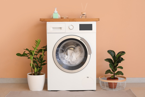 Renk duvarına yakın çamaşırları olan modern çamaşır makinesi. - Fotoğraf, Görsel