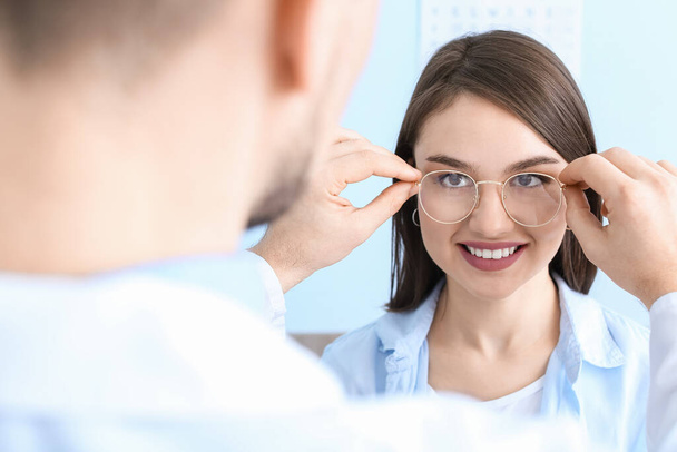Egy nő új szemüveget választ a szemész irodájában. - Fotó, kép