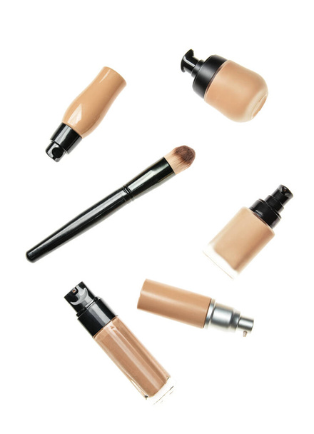 Garrafas de fundações tonais cosméticas e pincel de maquiagem em fundo branco - Foto, Imagem