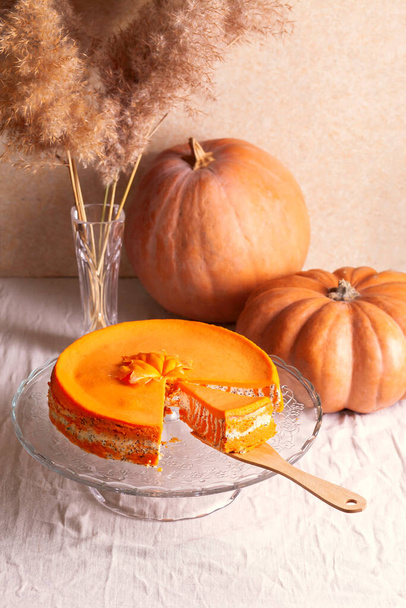 Homemade cottage cheese and pumpkin casserole with poppy seeds and orange on a glass stand on the table with pumpkins and reeds. - Foto, Imagem
