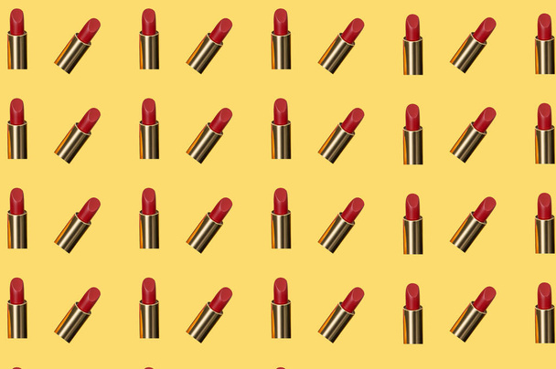 Creative pattern fashion photo of cosmetics beauty products red lipstick on a orange background - Photo, Image
