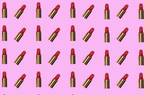Creative pattern fashion photo of cosmetics beauty products red lipstick on a pink background - Photo, Image