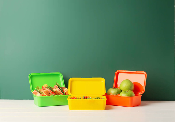 Boîtes à lunch avec légumes, sandwichs et pommes sur la table en classe - Photo, image