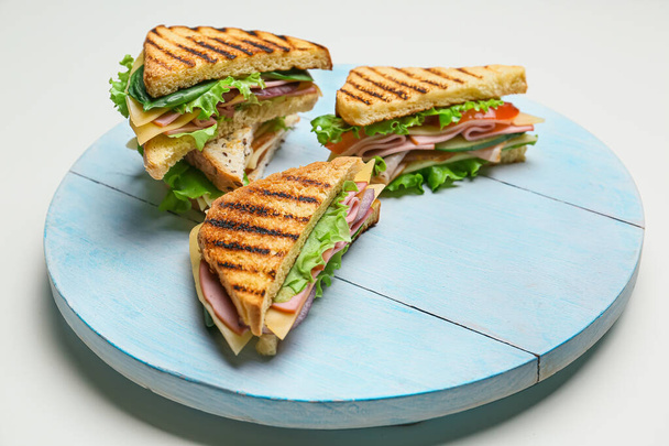 Placa com sanduíches saborosos no fundo branco - Foto, Imagem