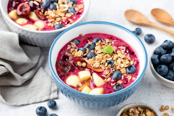 Superfood smoothie bowl with granola and berry topping. Low calorie vegan detox meal - Fotografie, Obrázek