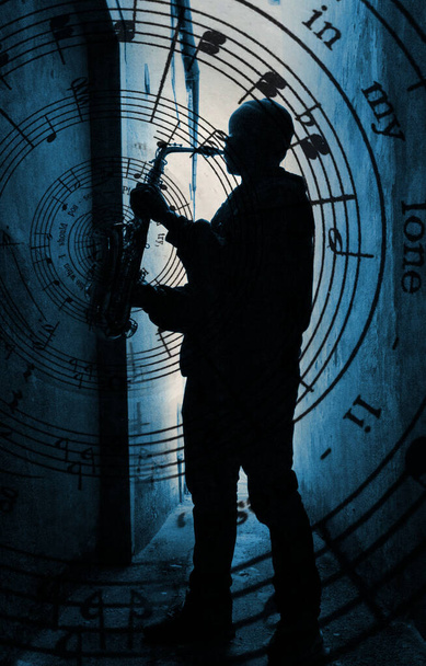  silhouette of a street saxophone player with music spiral and set against blue light  - Фото, изображение