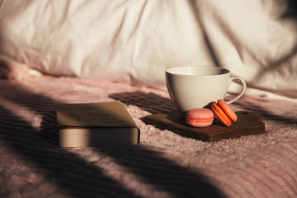 kuppi kahvia macaroons ja kirja sängyllä, kopioi tilaa käsite tausta  - Valokuva, kuva