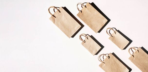 Recycled paper craft shopping bags, flat lay on light background, copy space. Sales or shopping concept. - Photo, Image