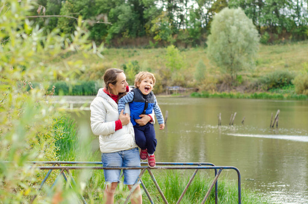 mother and child standing near beautiful pond - Fotografie, Obrázek