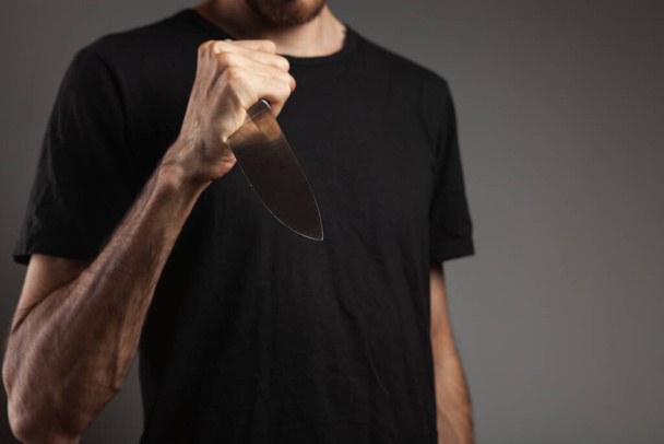 homme menace avec un couteau sur fond gris - Photo, image