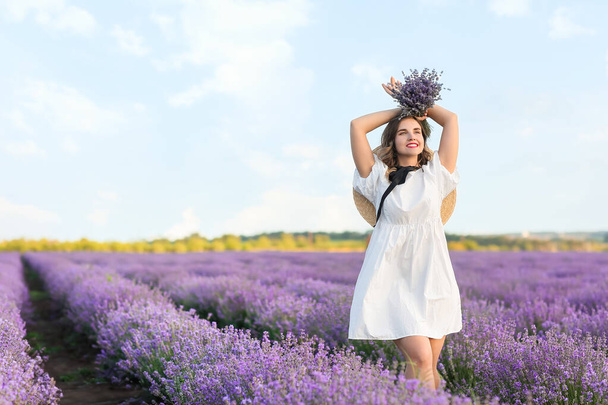 Mooie jonge vrouw in lavendelveld - Foto, afbeelding