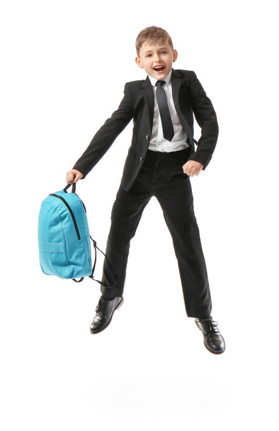 Jumping little schoolboy with backpack on white background - Fotografie, Obrázek