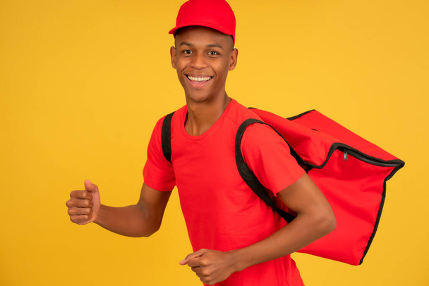 Portrait of a young delivery man showing thumb up. - Foto, imagen