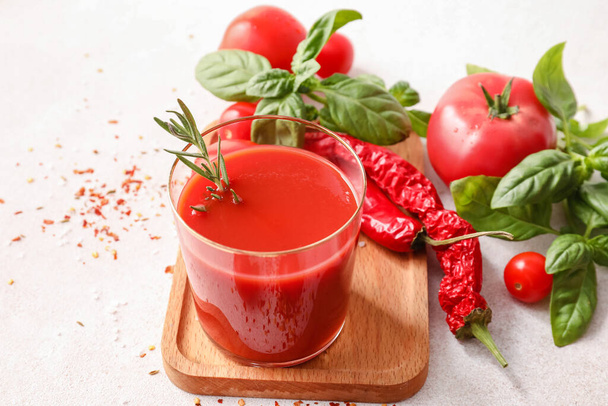 Glass of tasty tomato juice on light background - Valokuva, kuva