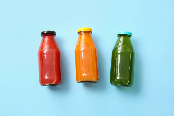 Bottles with healthy juice on color background - Фото, изображение