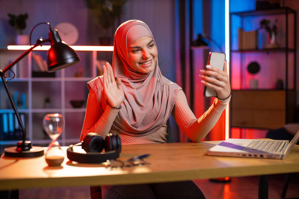 Woman in hijab using cell phone for taking selfie at home - Photo, image