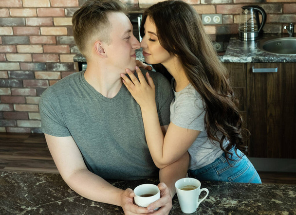 Молодая жена обнимает мужа за завтраком - Фото, изображение