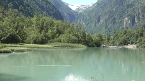 Vene purjehdus rauhallisella vedellä Klammsee järven näkymä Alppivuorille Kaprun, Itävalta. staattinen laukaus - Materiaali, video