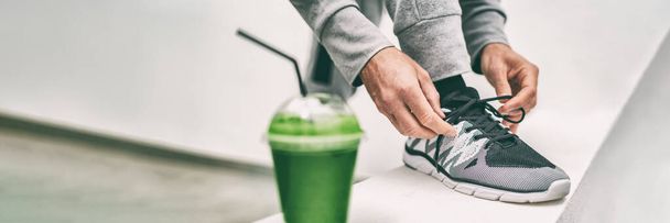Green juice weight loss smoothie fit man getting ready for cardio run workout tying running shoes laces drinking detox drink panoramic banner. Fitness runner athlete with healthy vegan juice - Fotoğraf, Görsel