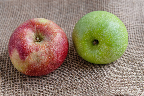rijp sappige rode en groene appels op jute doek close-up - Foto, afbeelding