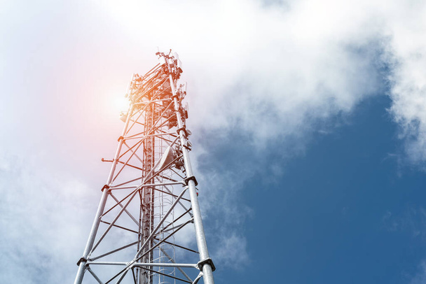Pohja näkökulma moderni metalli teräs mobiili 5g verkko langaton tietoliikenne torni vastaan kirkas sininen taivas tausta kirkkaana päivänä. Mikroaaltouuni signaali laajakaistalaitteet tukiaseman masto - Valokuva, kuva
