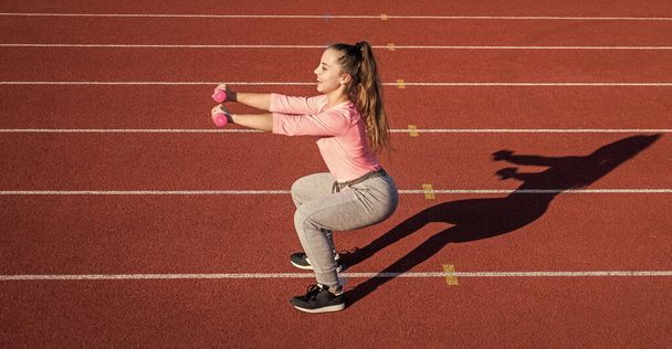 girl kid training sport with barbells outside on stadium arena, strength - Valokuva, kuva