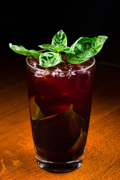 cherry lemonade with basil, dark red cocktail at the bar. Fresh homemade cherry lemonade on dark background. Summer refreshment drink - Fotoğraf, Görsel