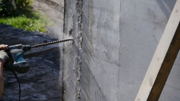 trabajador de la construcción perfora un agujero en una pared de hormigón - Metraje, vídeo