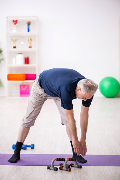 Old man doing sport exercises indoors - Photo, image