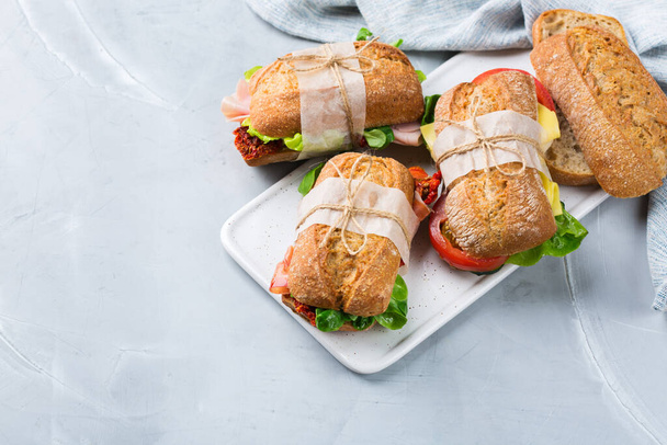 Fresh rye bread sandwich with ham, lettuce and tomato - Photo, image