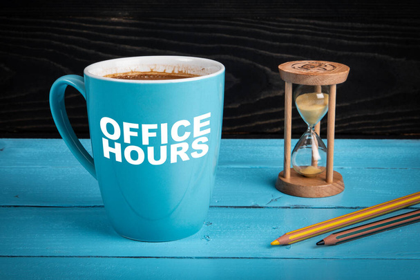 Horario de oficina. Taza de café, reloj de arena y lápices en el escritorio de la oficina - Foto, imagen