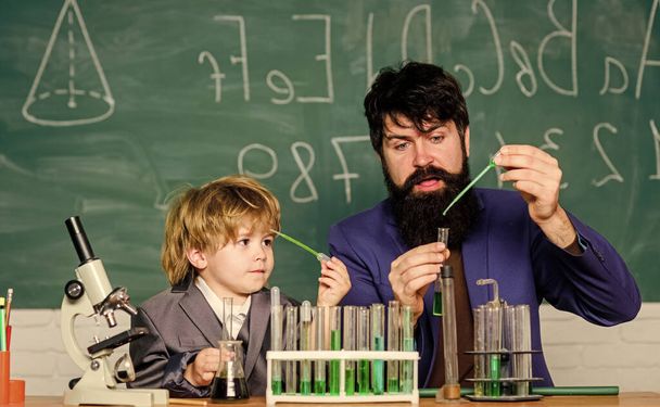 bearded man teacher with little boy. father and son child at school. Laboratory test tubes and flasks with colored liquids Chemistry experiment. laboratory research and development. Drop the base - Φωτογραφία, εικόνα