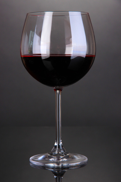 Red wine glass on grey background - Fotoğraf, Görsel