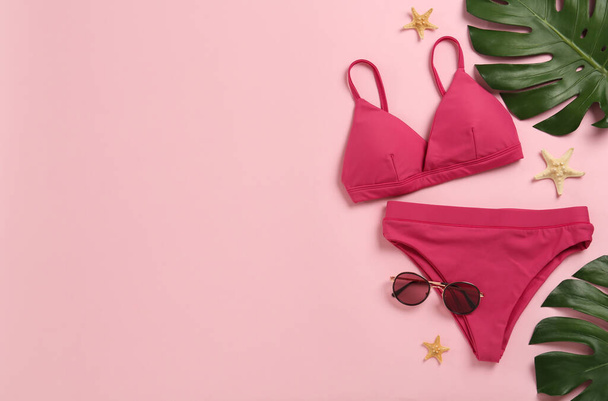Stylish bikini and beach accessories on pink background, flat lay. Space for text - Фото, зображення